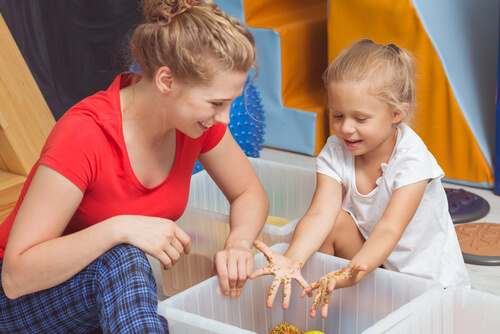 ילדה משחקת בחול מיוחד לויסות חושי